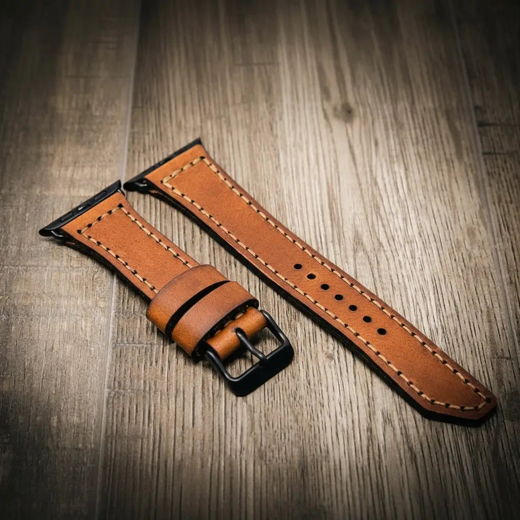 Brown full-grain leather Apple Watch band with contrast stitching and black buckle.