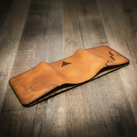 Trinity western trifold wallet in saddle tan leather, featuring intricate stitching and a smooth finish, handmade in the USA by Bull Sheath Leather.